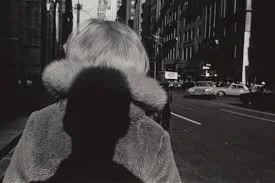 Lee Friedlander, the photographer's shadow and a figure on the street.